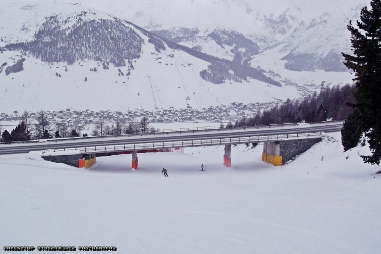 Jedna z dwóch głównych nartostrad prowadzących do Livigno z kompleksu Mottolino. Na tej nartostradzie  przejeżdża się pod mostem, a na drugiej z kolei przejeżdża się dwa razy mostami. W tle widać kawałek kompleksu Carosello 3000