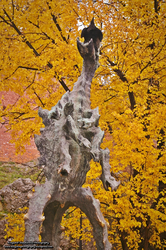 Rzeźba Smoka Wawelskiego, a w tle jesienne kolory.
